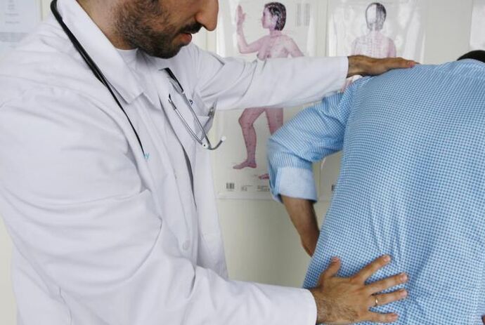 Der Arzt untersucht einen Patienten mit Rückenschmerzen im Lendenbereich